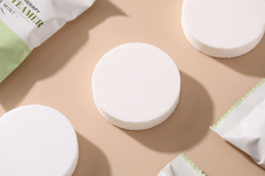 Close-up of white round aromatherapy shower steamer tablets on a beige background
