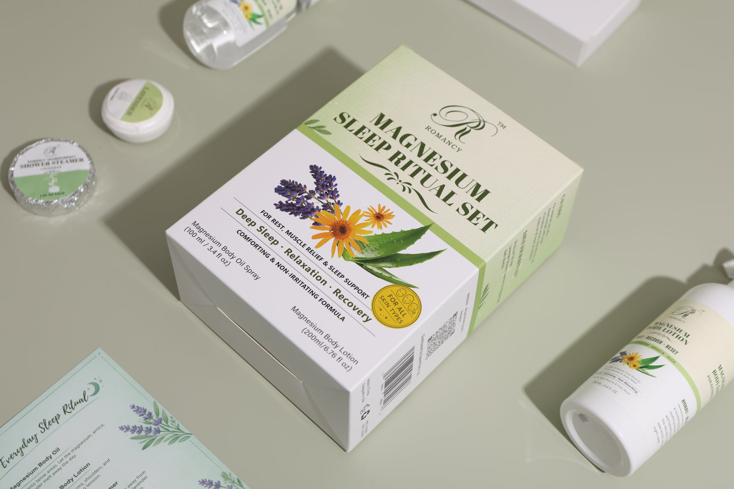 Romancy magnesium sleep ritual set box with botanical design, shown at an angle on a soft green background with included products
